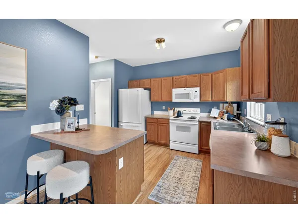 a kitchen with a dining table chairs and a refrigerator