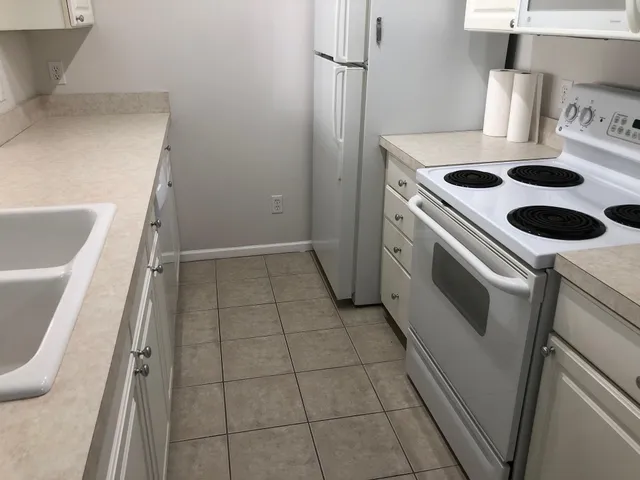 a kitchen with white cabinets and white appliances