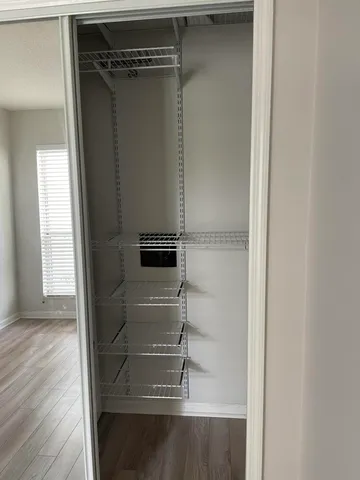 a view of walk in closet with wooden floor