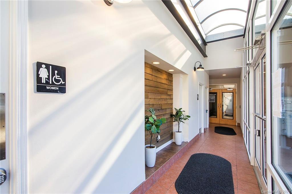 442 South Main Street, Unit 24 Davidson, NC 28036 - Photo 6 of 25 a hallway with wooden floor and a potted plant