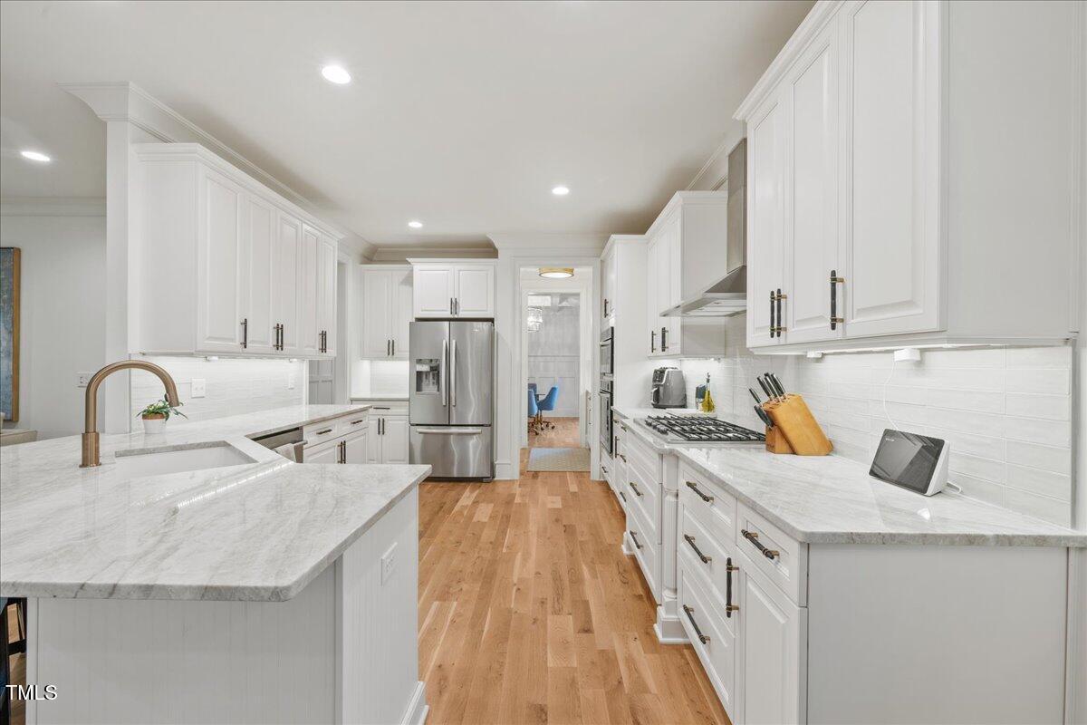 2926 Barmettler Street Raleigh, NC 27607 - Photo 11 of 74 a kitchen with stainless steel appliances granite countertop a sink a stove and a refrigerator