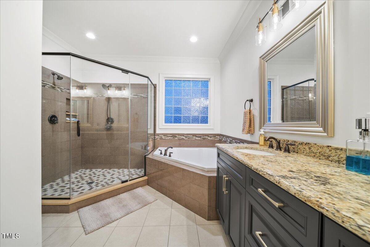 2926 Barmettler Street Raleigh, NC 27607 - Photo 40 of 74 a bathroom with a granite countertop sink a mirror a bathtub and shower