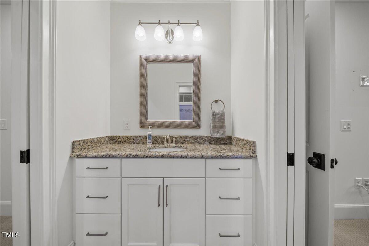 2926 Barmettler Street Raleigh, NC 27607 - Photo 47 of 74 a bathroom with a granite countertop sink and a mirror