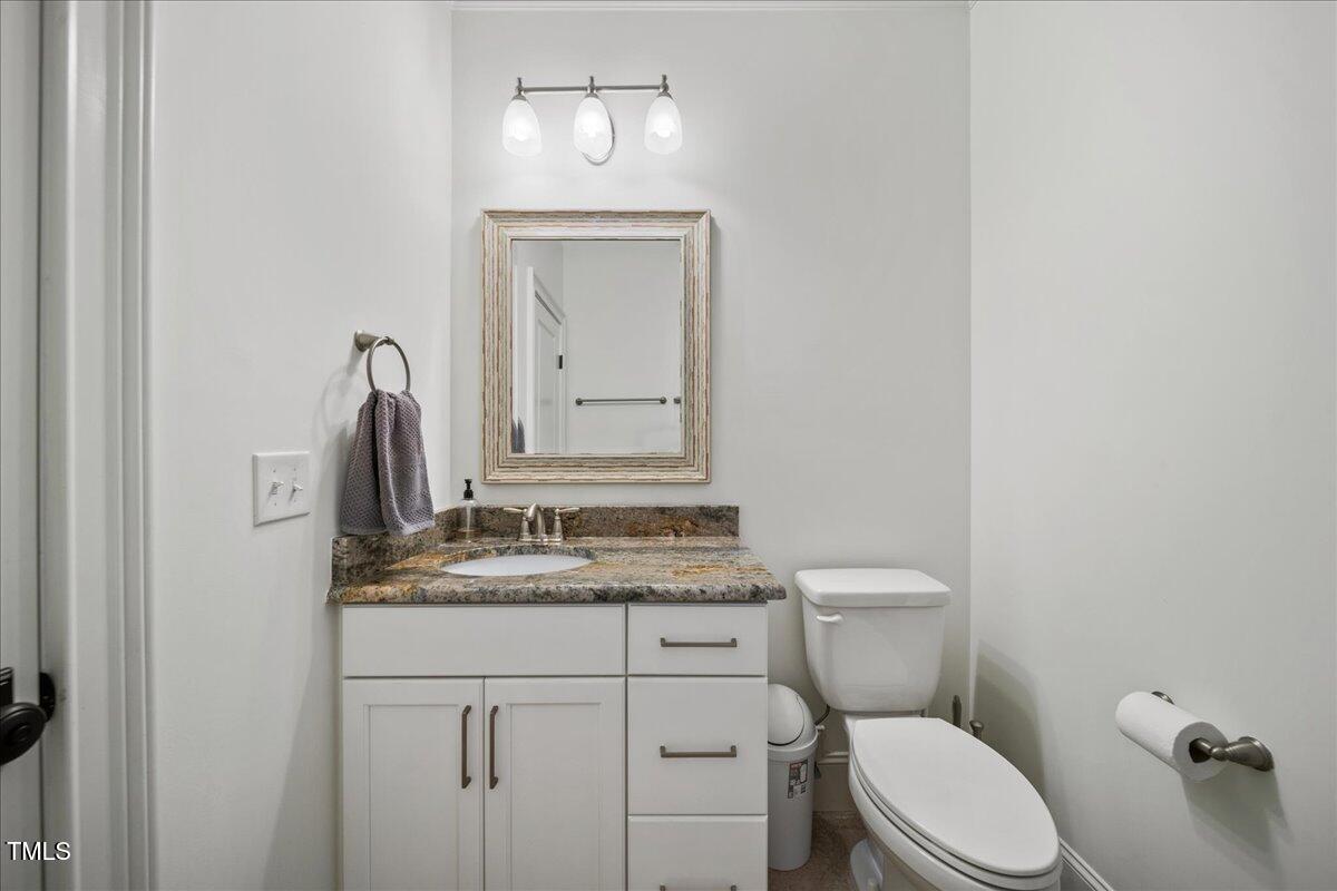 2926 Barmettler Street Raleigh, NC 27607 - Photo 53 of 74 a bathroom with a granite countertop toilet sink and mirror