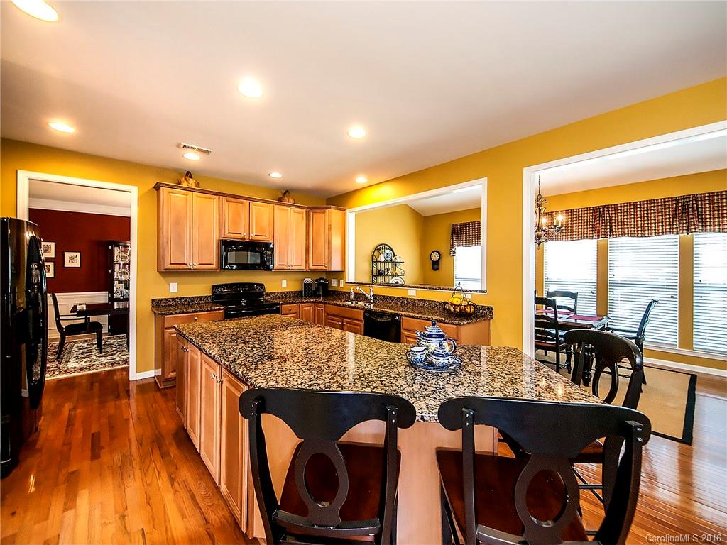 623 Panthers Way Fort Mill, SC 29708 - Photo 7 of 24 a kitchen with stainless steel appliances granite countertop sink stove and wooden cabinets