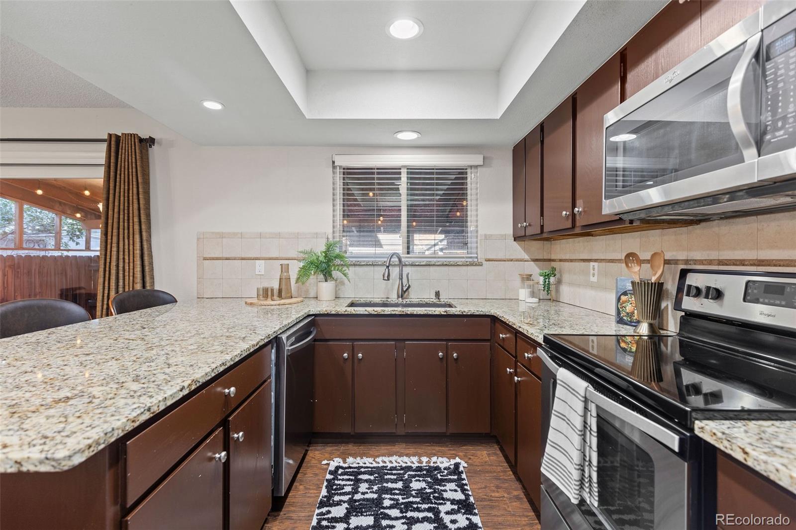 9149 Mansfield Avenue, Unit L Denver, CO 80237 - Photo 15 of 35 a kitchen with a sink stove and granite counter top