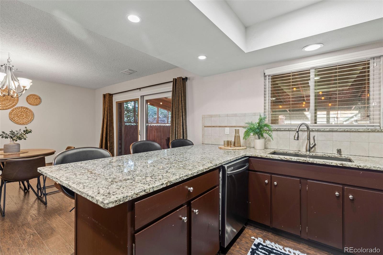 9149 Mansfield Avenue, Unit L Denver, CO 80237 - Photo 16 of 35 a kitchen with granite countertop sink table and chairs