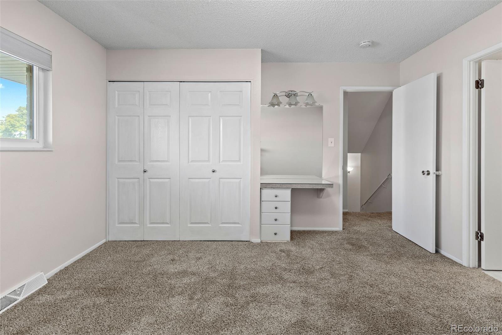 9149 Mansfield Avenue, Unit L Denver, CO 80237 - Photo 21 of 35 an empty room with a cabinet and mirrors