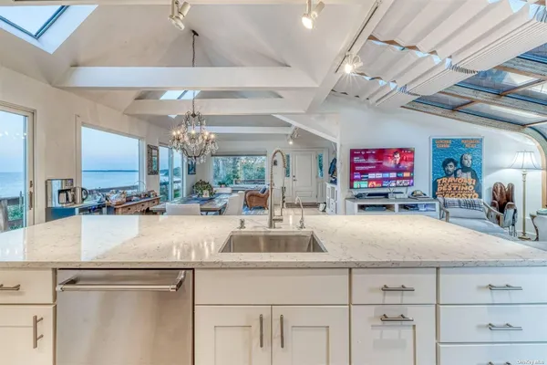 a kitchen with kitchen island a counter top space a sink and chandelier