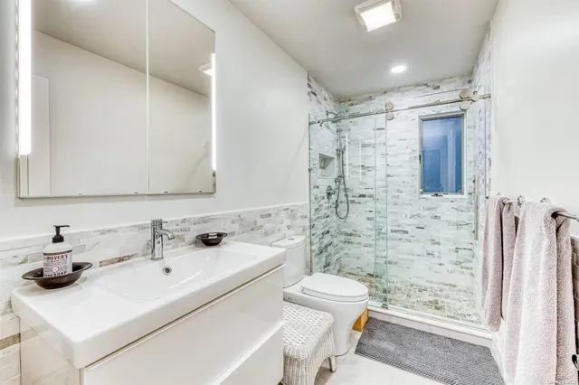 a bathroom with a sink toilet and shower