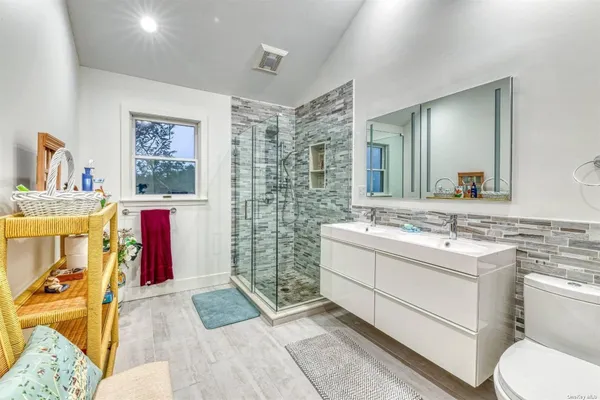a bathroom with a sink mirror vanity and toilet