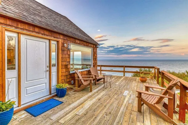 a view of a balcony with chairs and wooden floor