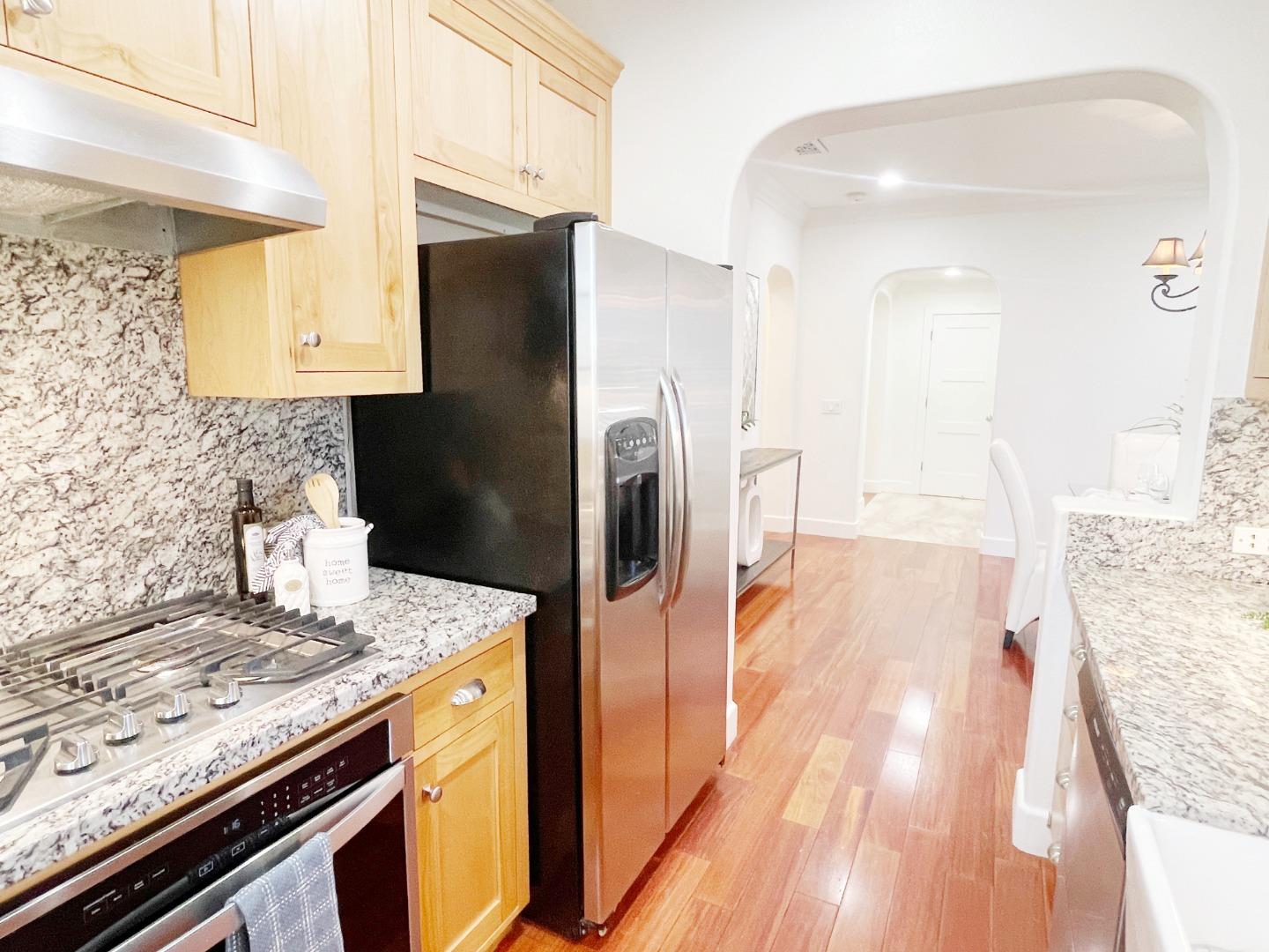 1325 Dahlia Loop San Jose, CA 95126 - Photo 9 of 31 a kitchen with stainless steel appliances granite countertop a refrigerator a stove and a sink with wooden floor