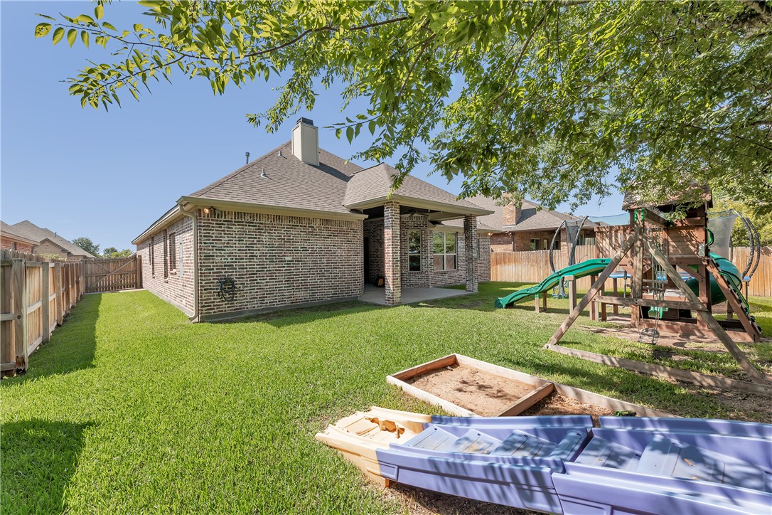 8312 Raintree Drive College Station, TX 77845 - Photo 29 of 30 Spacious backyard featuring a covered patio, brick exterior, and wood fencing