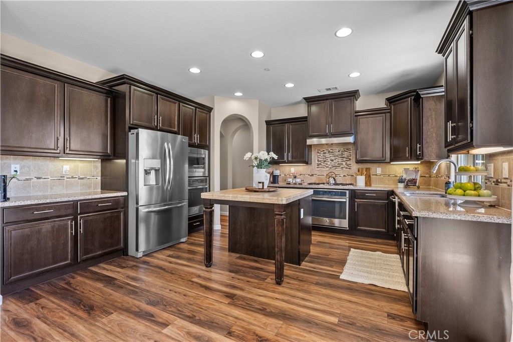 28640 Farrier Drive Valencia, CA 91354 - Photo 13 of 67 a kitchen with stainless steel appliances kitchen island granite countertop a refrigerator stove top oven and sink