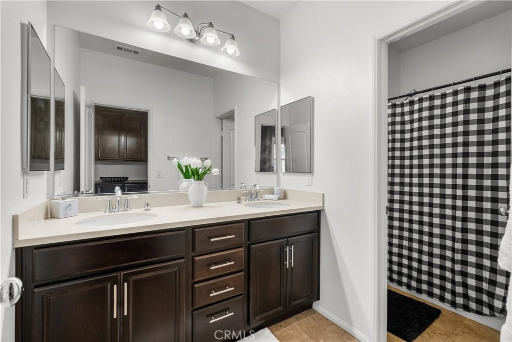 28640 Farrier Drive Valencia, CA 91354 - Photo 28 of 67 a bathroom with a sink vanity and a mirror