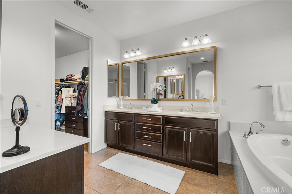 28640 Farrier Drive Valencia, CA 91354 - Photo 32 of 67 a spacious bathroom with a granite countertop sink a mirror and bathtub