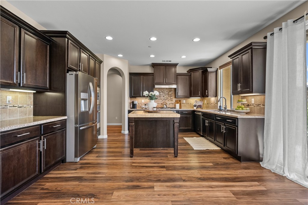 28640 Farrier Drive Valencia, CA 91354 - Photo 10 of 67 a kitchen with kitchen island granite countertop wooden cabinets and stainless steel appliances