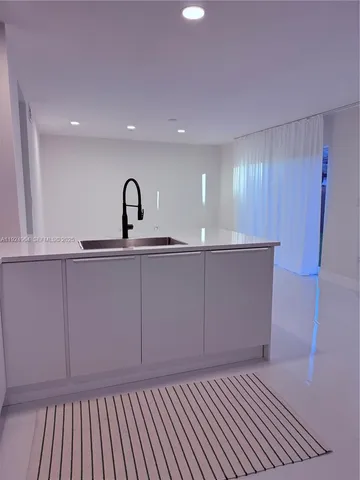 a view of a room with a sink and cabinets
