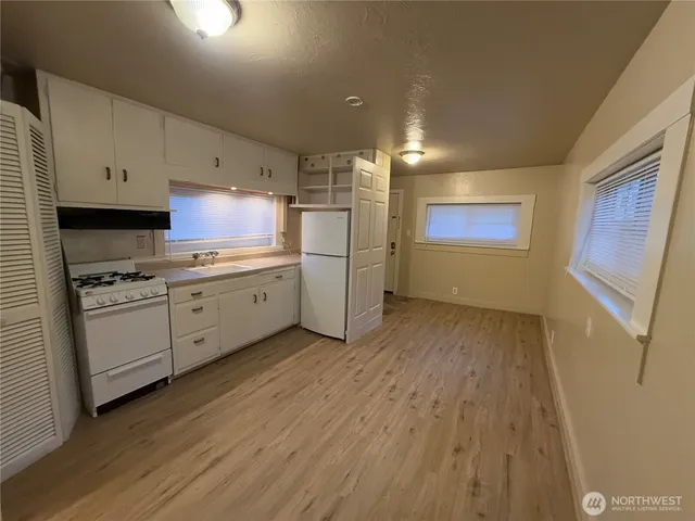 a kitchen with stainless steel appliances a sink cabinets and wooden floor
