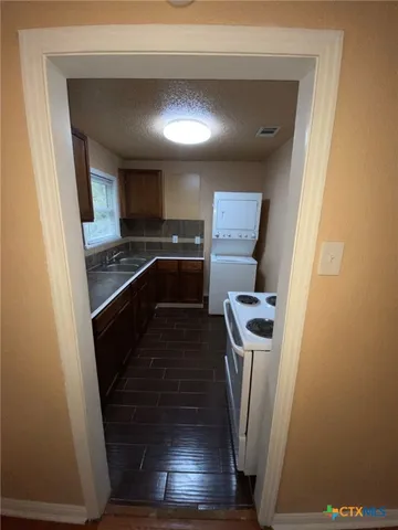 a kitchen with granite countertop a refrigerator a stove and a sink
