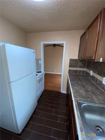 a kitchen with cabinets and a refrigerator