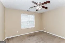 an empty room with a window and a fan