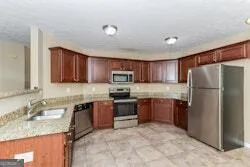 a kitchen with stainless steel appliances granite countertop a refrigerator stove top oven a sink and dishwasher