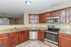a kitchen with granite countertop a sink stainless steel appliances and cabinets