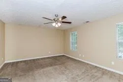 an empty room with a window and a ceiling fan