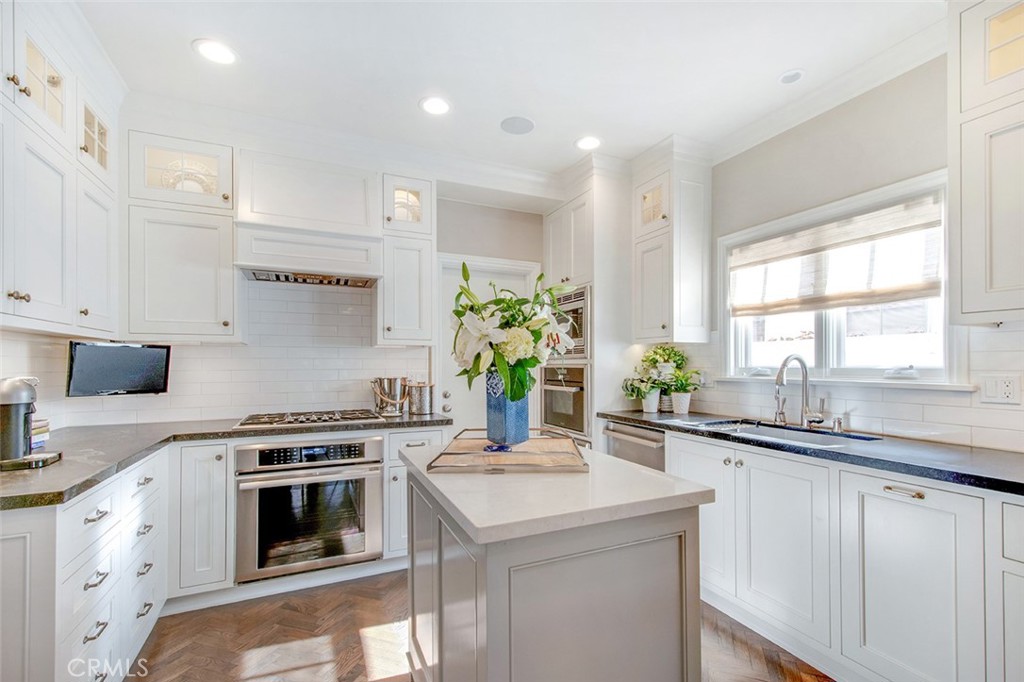 213 Via Firenze Newport Beach, CA 92663 - Photo 12 of 41 a kitchen with a sink stove and white cabinets