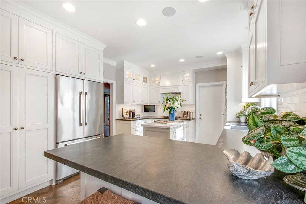 213 Via Firenze Newport Beach, CA 92663 - Photo 16 of 41 a kitchen with stainless steel appliances kitchen island granite countertop a refrigerator a stove a sink dishwasher and white cabinets with wooden floor