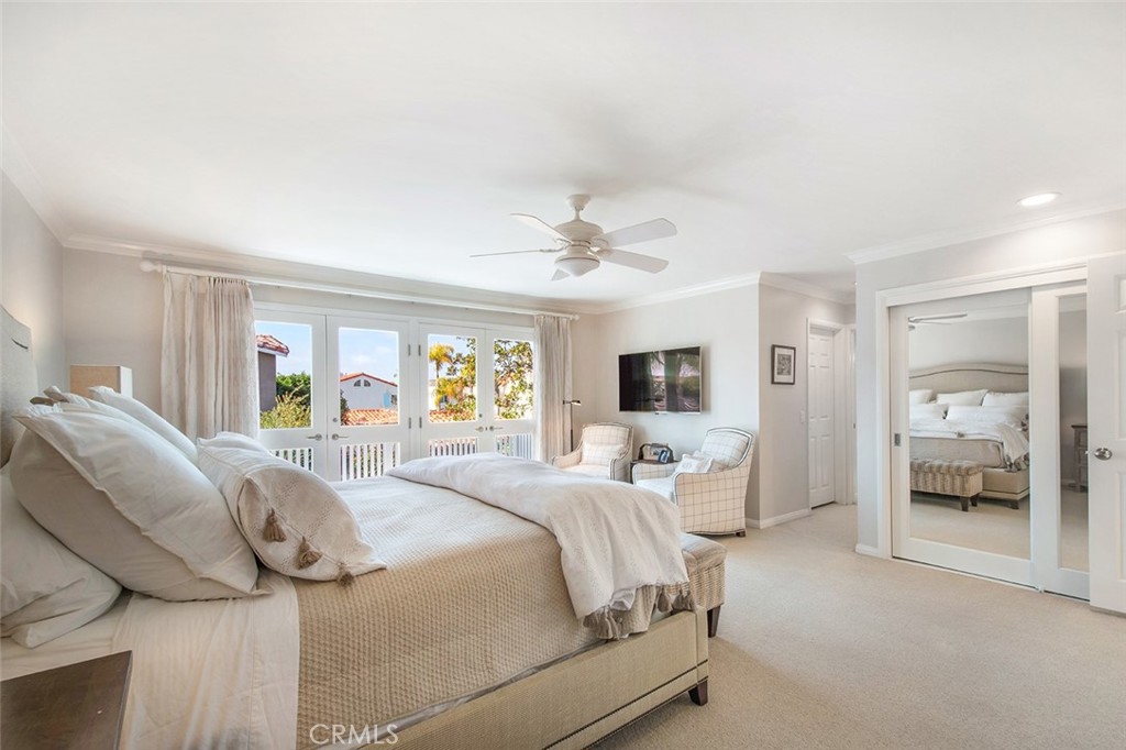 213 Via Firenze Newport Beach, CA 92663 - Photo 26 of 41 a bedroom with a bed and a large mirror