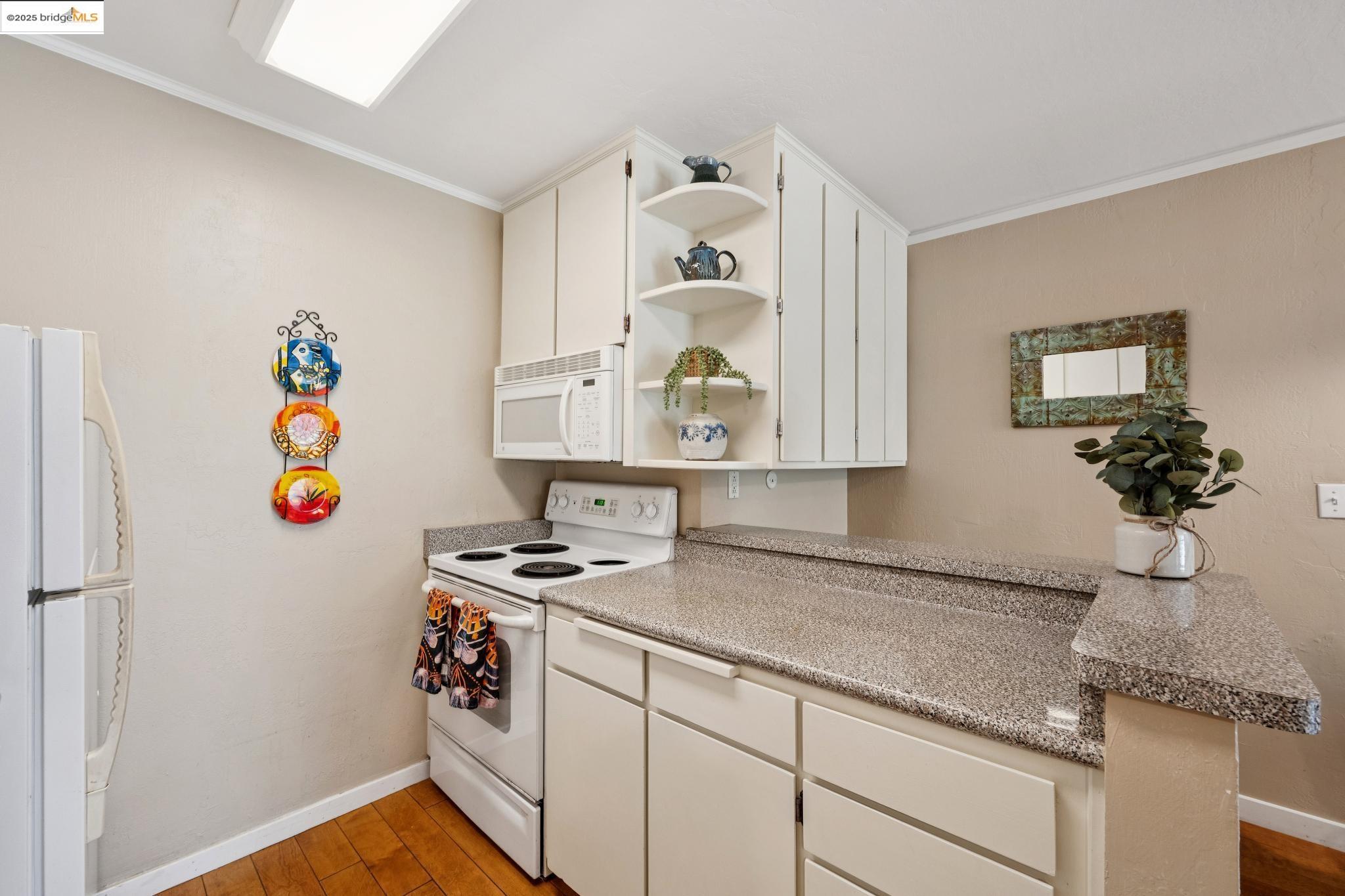 250 Whitmore Street Oakland, CA 94611 - Photo 19 of 33 Kitchen featuring open shelves, ornamental molding, white appliances, light wood-style flooring, and light countertops
