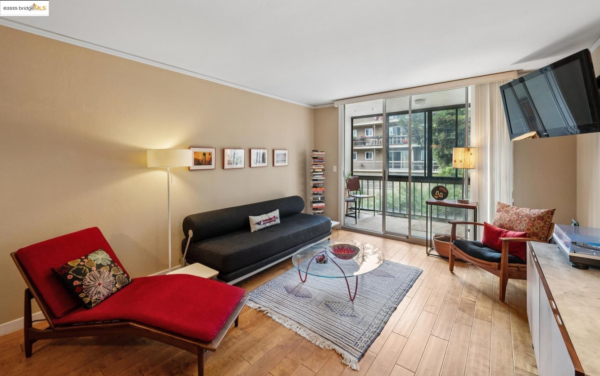 250 Whitmore Street Oakland, CA 94611 - Photo 6 of 33 Living area featuring floor to ceiling windows, light wood-style floors, and ornamental molding