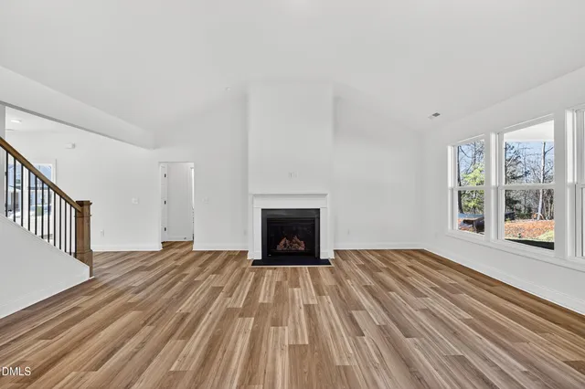 a spacious bedroom with a bed and chair