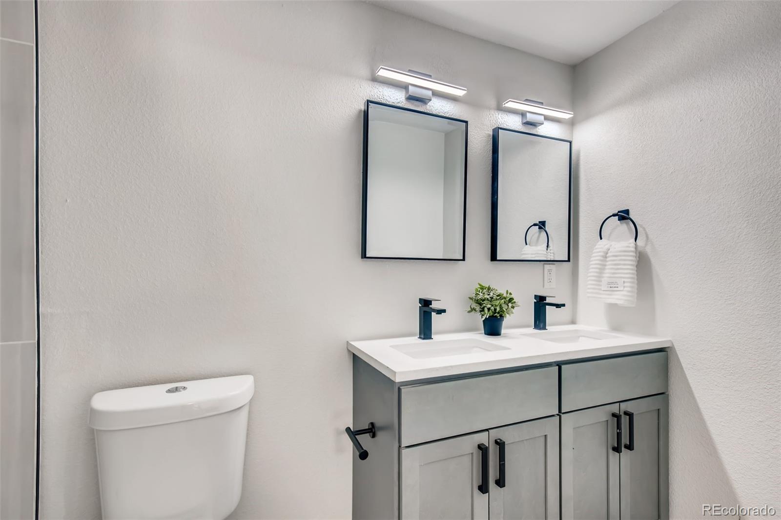 2925 Eaton Street Wheat Ridge, CO 80214 - Photo 18 of 30 a bathroom with a toilet sink and mirror