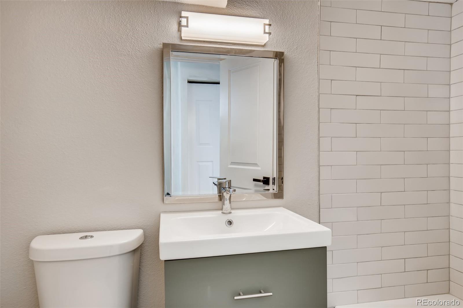 2925 Eaton Street Wheat Ridge, CO 80214 - Photo 25 of 30 a bathroom with a sink a toilet and mirror