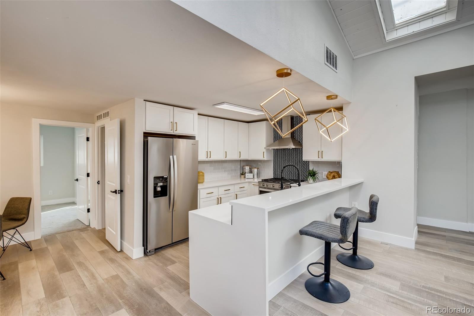 2925 Eaton Street Wheat Ridge, CO 80214 - Photo 10 of 30 a view of a kitchen with furniture and wooden floor