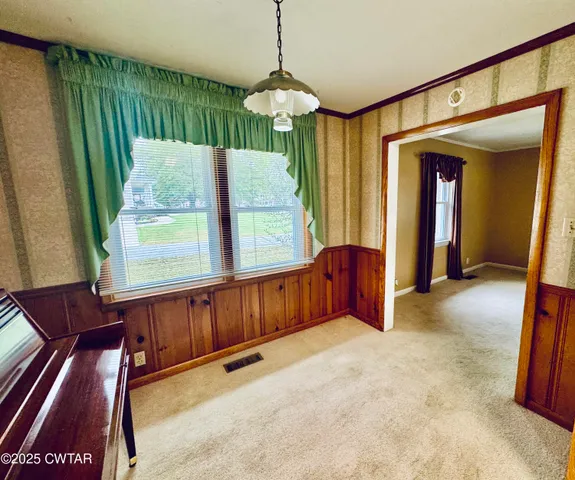 a view of a hallway with furniture and chandelier
