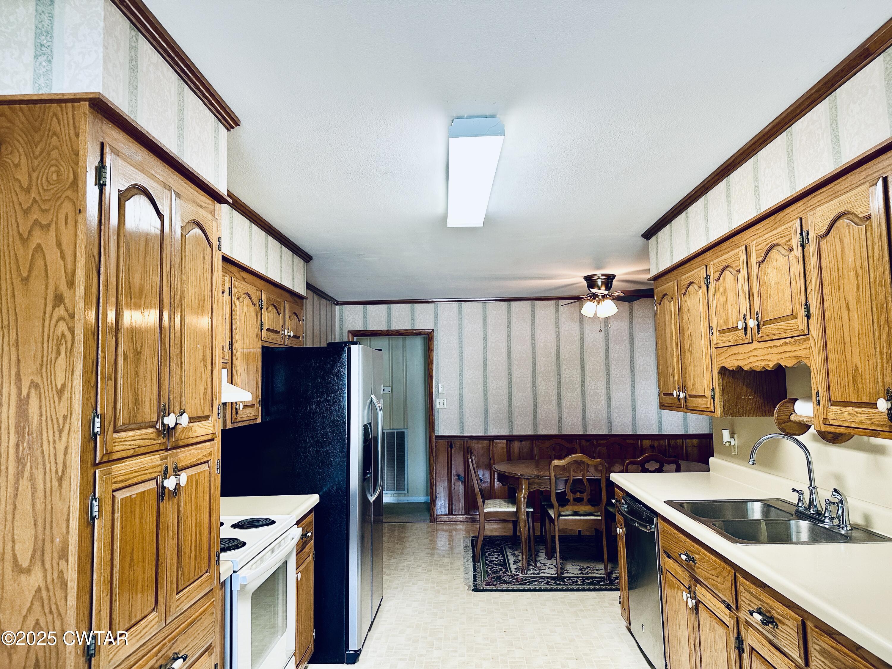 502 West Main Street Rutherford, TN 38369 - Photo 19 of 34 a kitchen with stainless steel appliances granite countertop a refrigerator a sink dishwasher a stove and a dining table with wooden floor