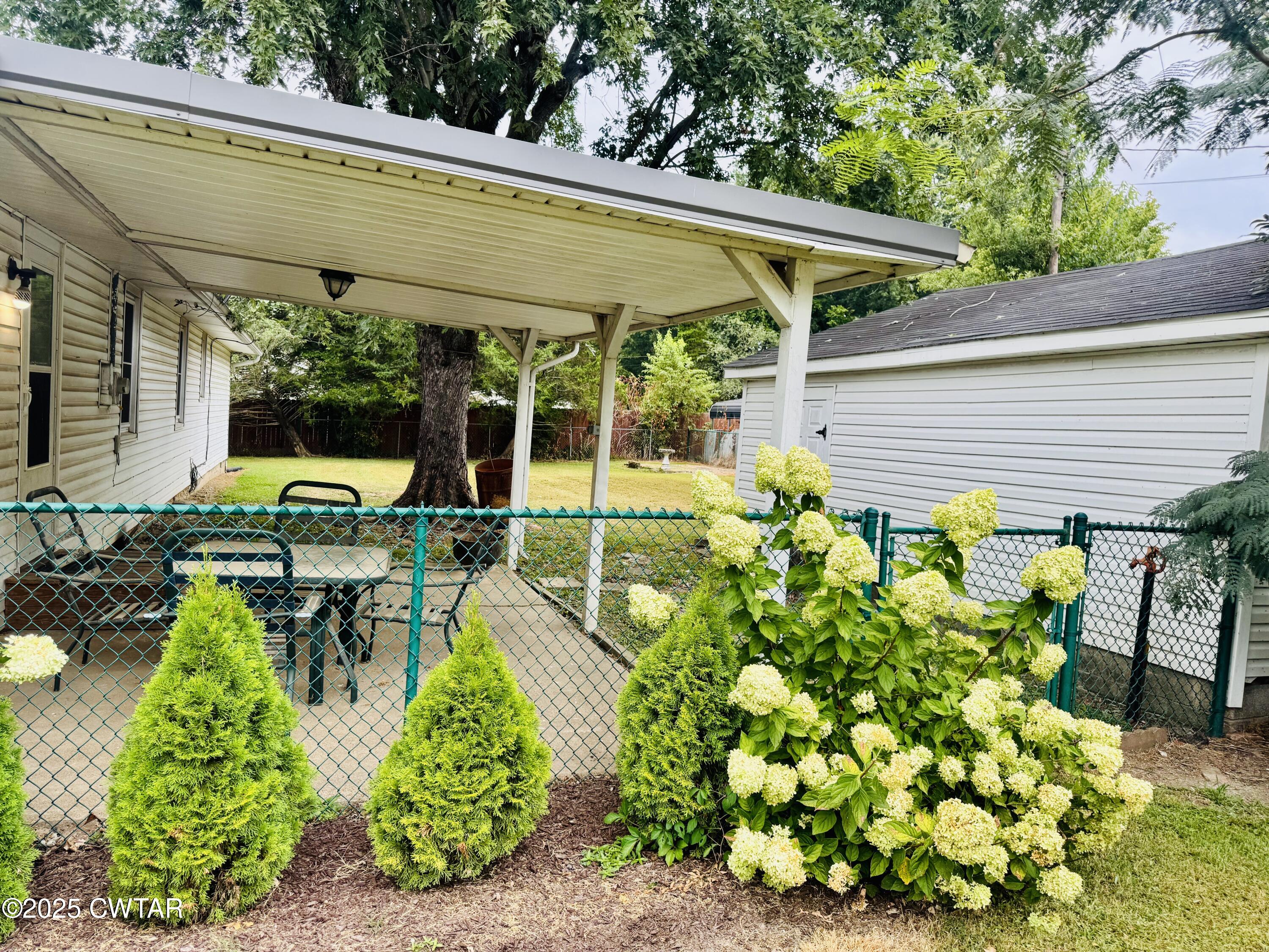502 West Main Street Rutherford, TN 38369 - Photo 9 of 34 a view of a patio with table and chairs potted plants and large tree