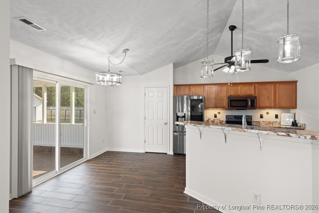 6649 Hillbrook Road Hope Mills, NC 28348 - Photo 13 of 37 a view of a kitchen with granite countertop stainless steel appliances cabinets and a wooden floor