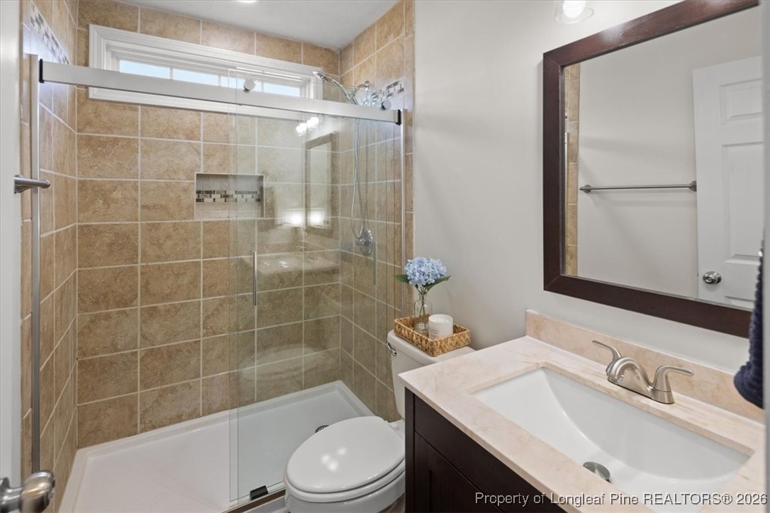 6649 Hillbrook Road Hope Mills, NC 28348 - Photo 24 of 37 a bathroom with a sink toilet a mirror and shower