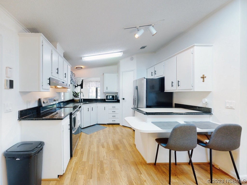 503 Halyard Circle Edgewater, FL 32141 - Photo 8 of 50 a kitchen with stainless steel appliances granite countertop a table chairs sink and cabinets