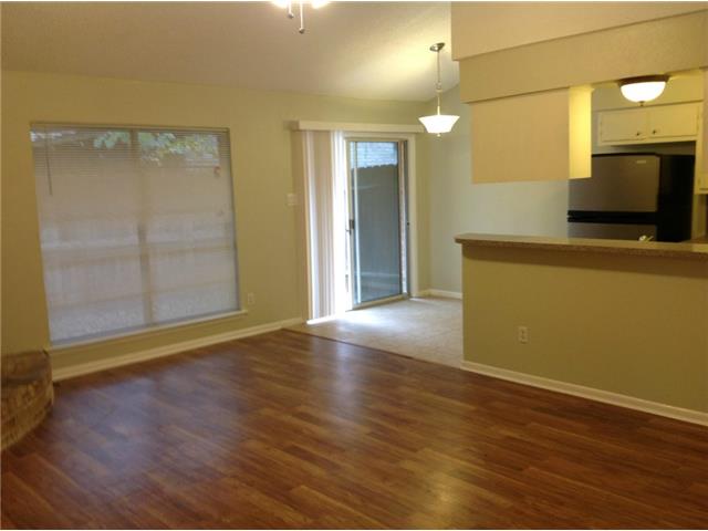 1601 Rutland Drive, Unit A Austin, TX 78758 - Photo 3 of 7 an empty room with wooden floor and windows