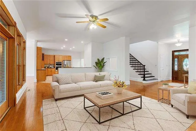 an empty room with wooden floor fireplace and windows