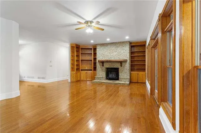 a view of a livingroom with a fireplace a ceiling fan and a fireplace