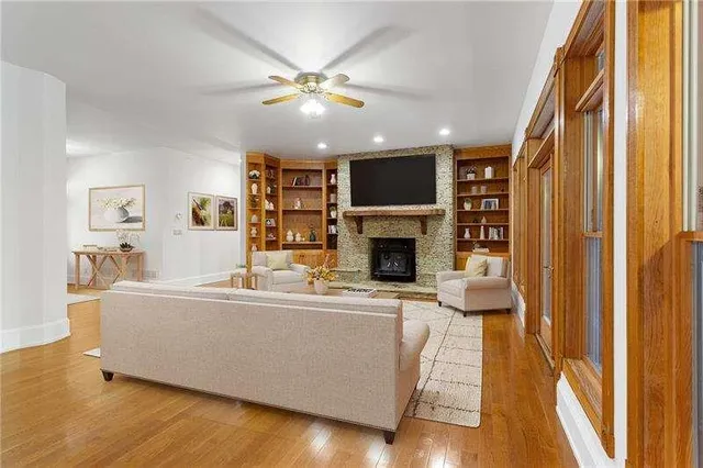 a view of an empty room with wooden floor and a fireplace