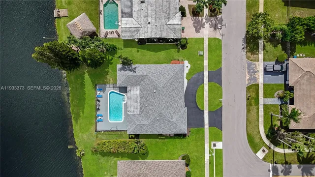 an aerial view of a house with swimming pool outdoor seating and yard